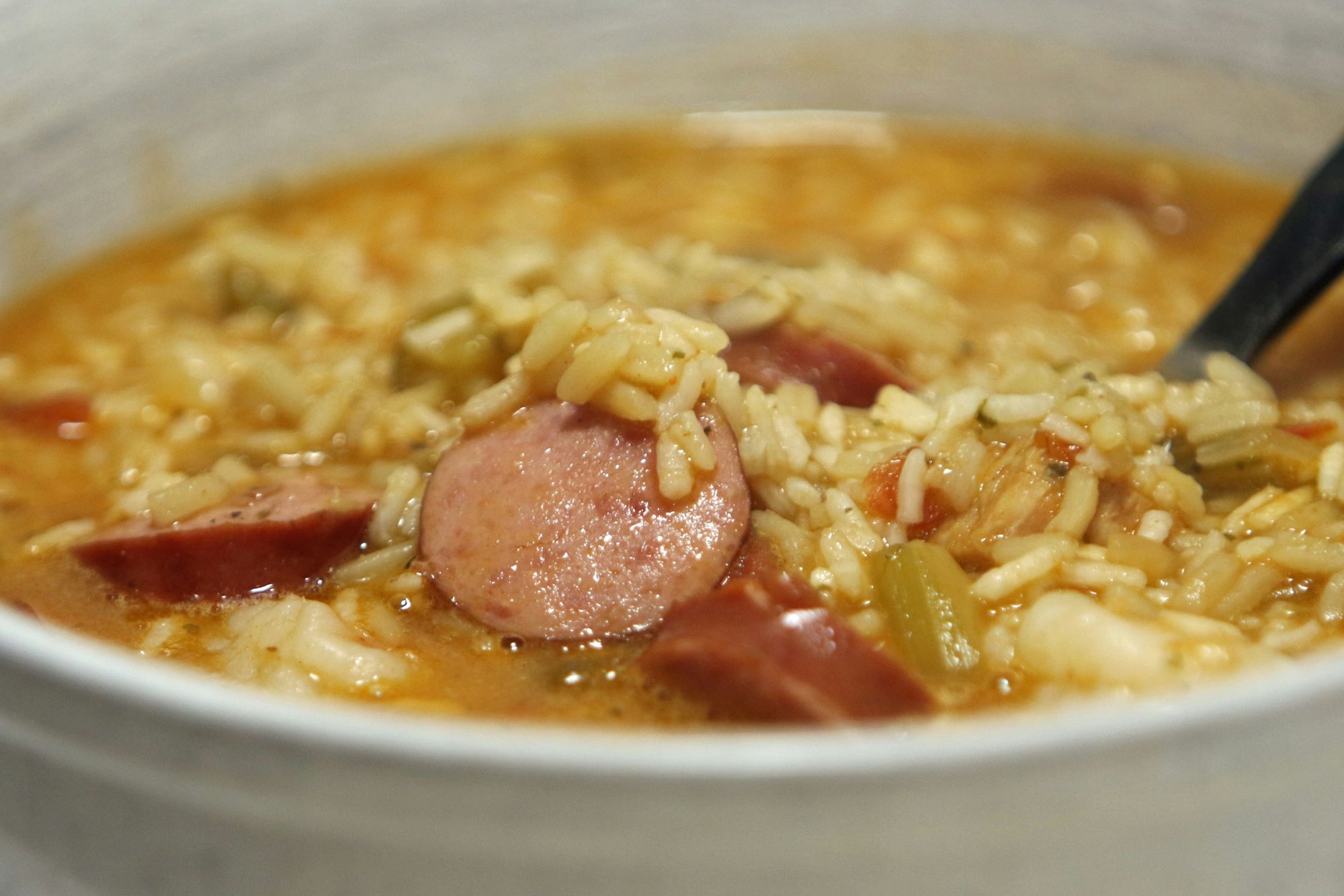 a bowl of gumbo with spoon in it